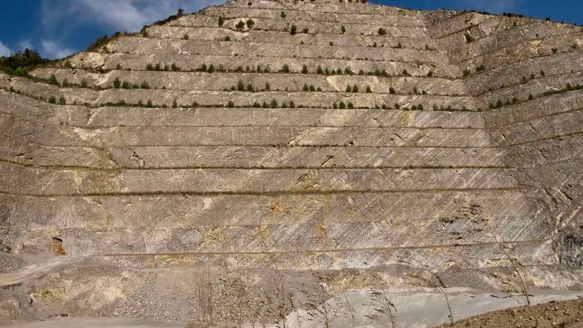 Cantera con sedimentos estratificados que registran el colapso oceánico anóxico del Jurásico debido al exceso de CO₂.