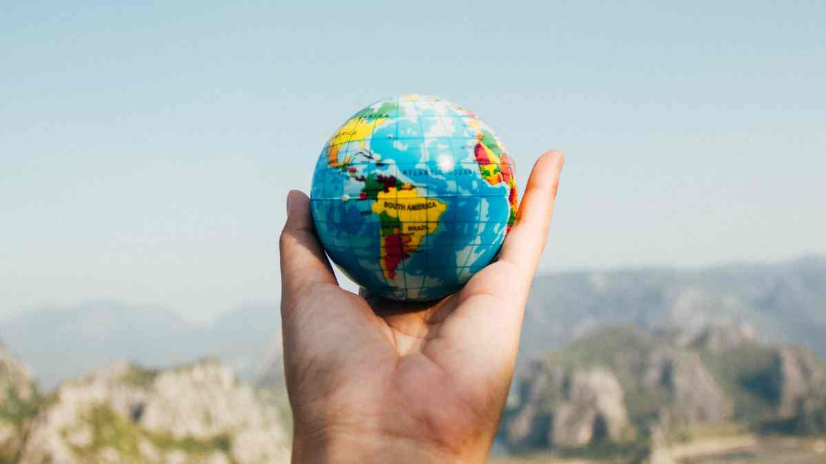 Mano sosteniendo un globo terráqueo simbolizando el futuro del planeta sin humanos.