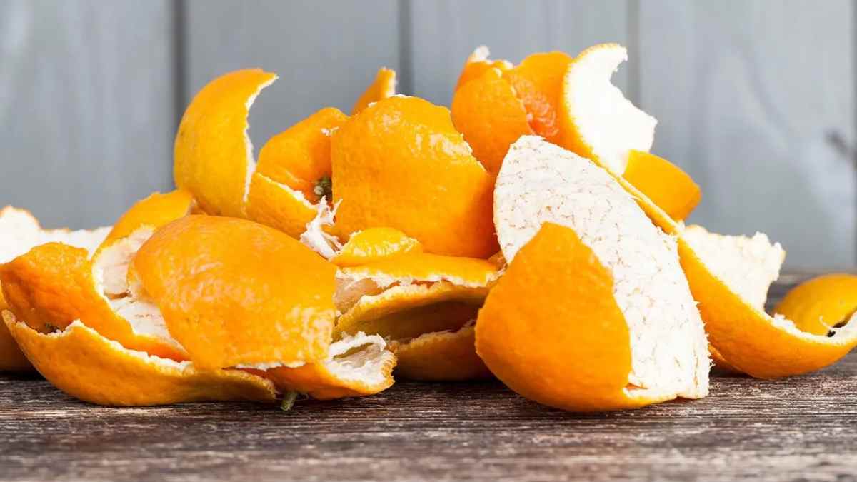 cáscaras de mandarina secas apiladas sobre una mesa de madera.