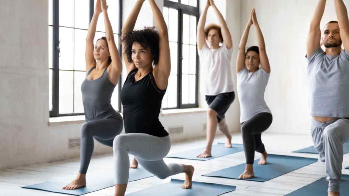 grupo de adultos practicando yoga adaptado en postura de estocada para aliviar dolores articulares despues de los 65 años.