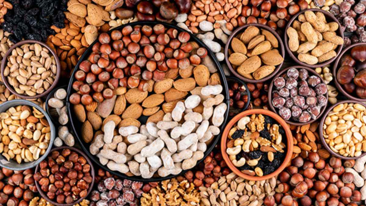 Plato con variedad de frutos secos, destacando nueces pecanas, aliadas para reducir el colesterol y cuidar el corazón.