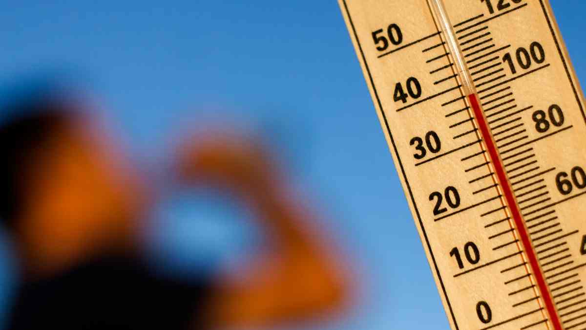 Termómetro con altas temperaturas y persona hidratándose para combatir el calor en verano