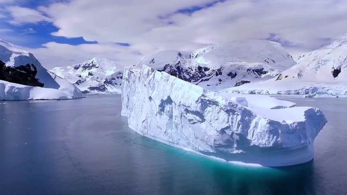 Antártida: iceberg ante montañas nevadas donde se halló una cadena montañosa oculta de 500 millones de años.