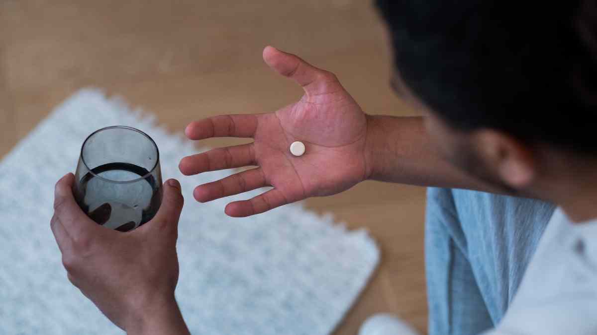 Persona tomando una pastilla para dormir que podría prevenir el Alzheimer