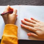 Persona zurda escribiendo en un cuaderno; la ciencia concluye que ser zurdo no aumenta la creatividad.
