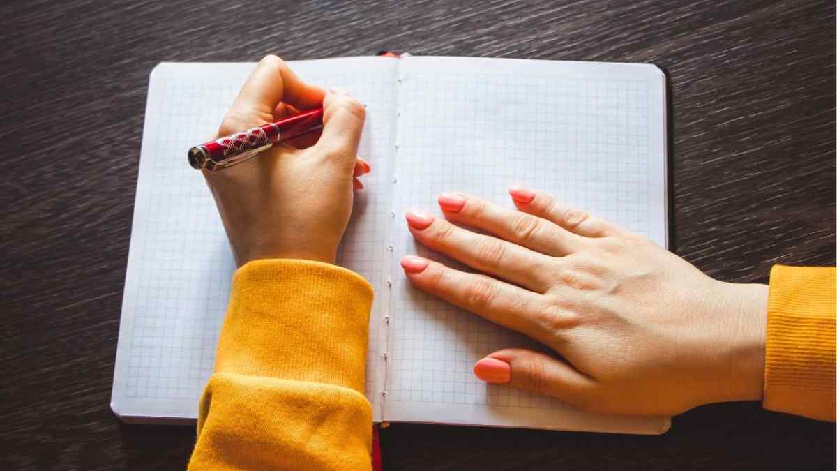 Persona zurda escribiendo en un cuaderno; la ciencia concluye que ser zurdo no aumenta la creatividad.