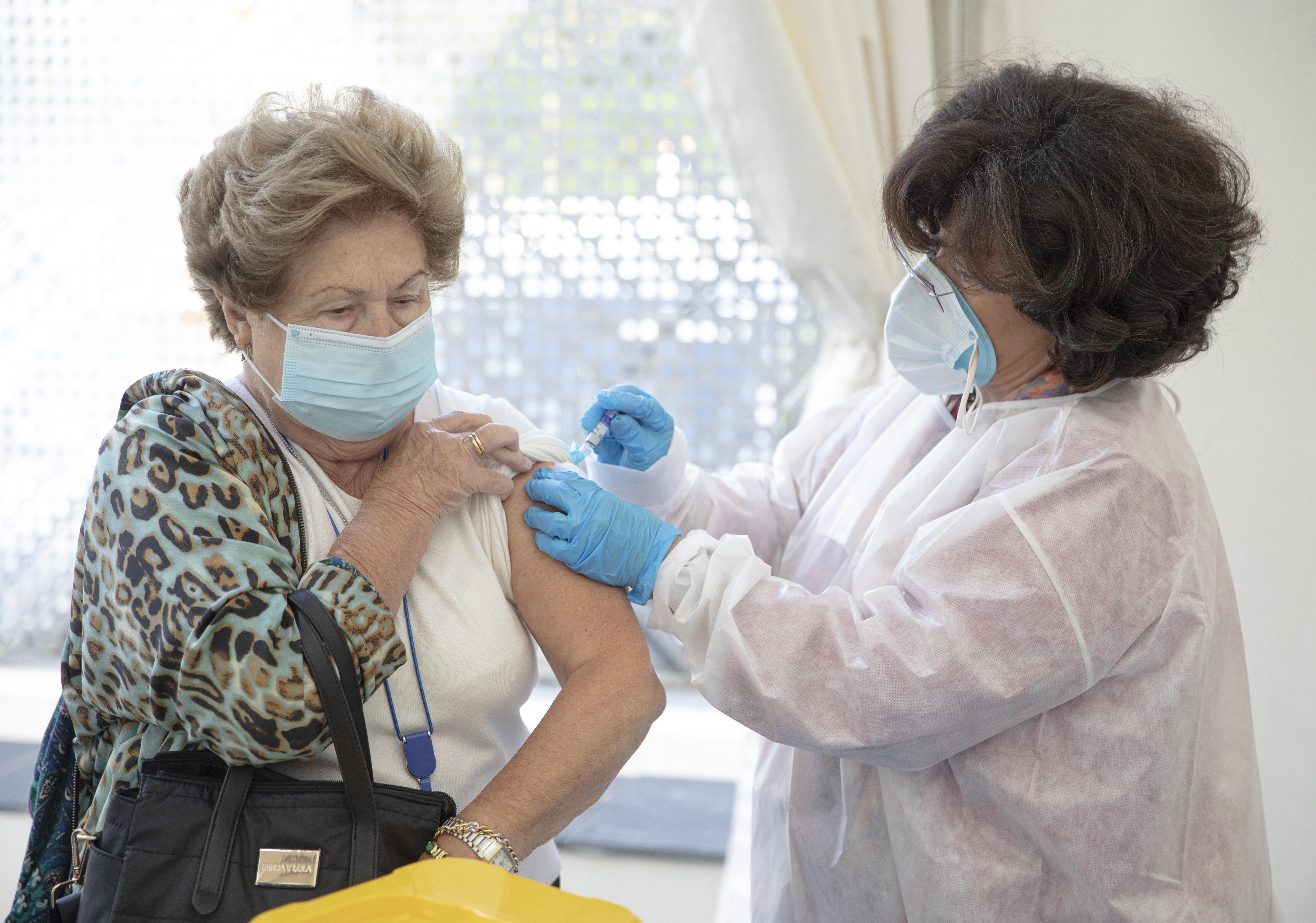 Una mujer vacunándose por una médica contra la gripe