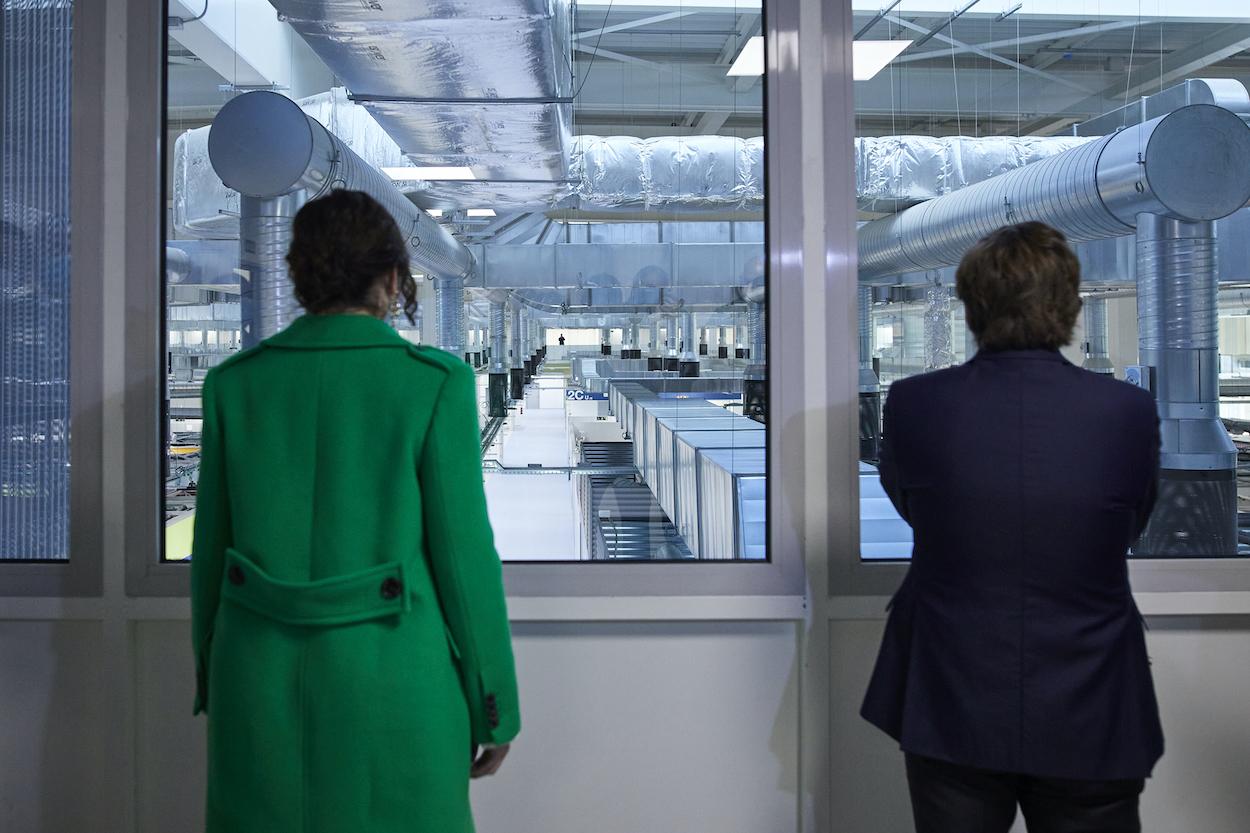 La presidenta de la Comunidad de Madrid, Isabel Díaz Ayuso, y el alcalde de Madrid, José Luis Martínez Almeida, miran tras una ventana hacia el interior del del Hospital Isabel Zendal,