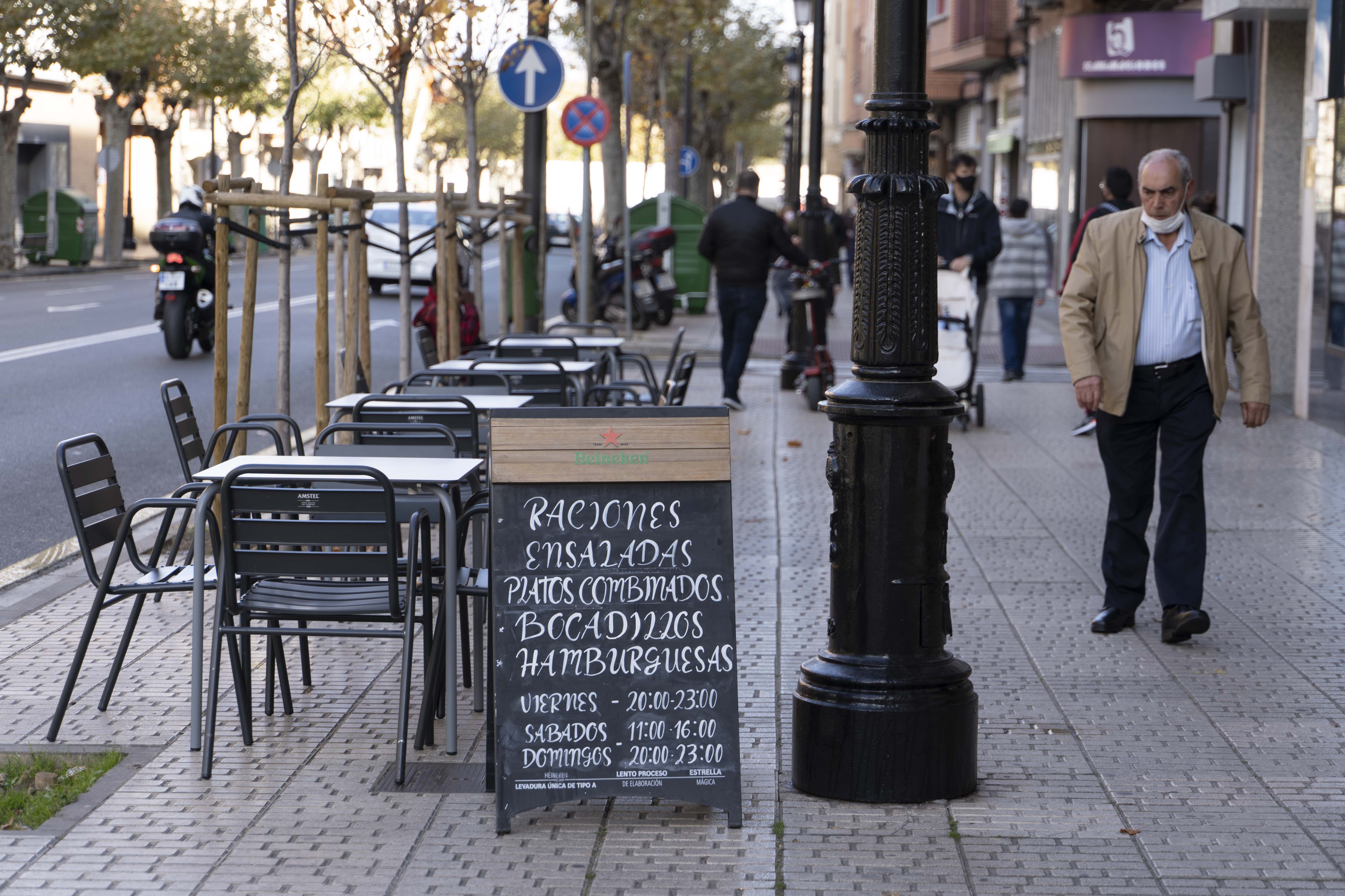 Un hombre camina frente a la terraza de un bar. Fuente: Europa Press.