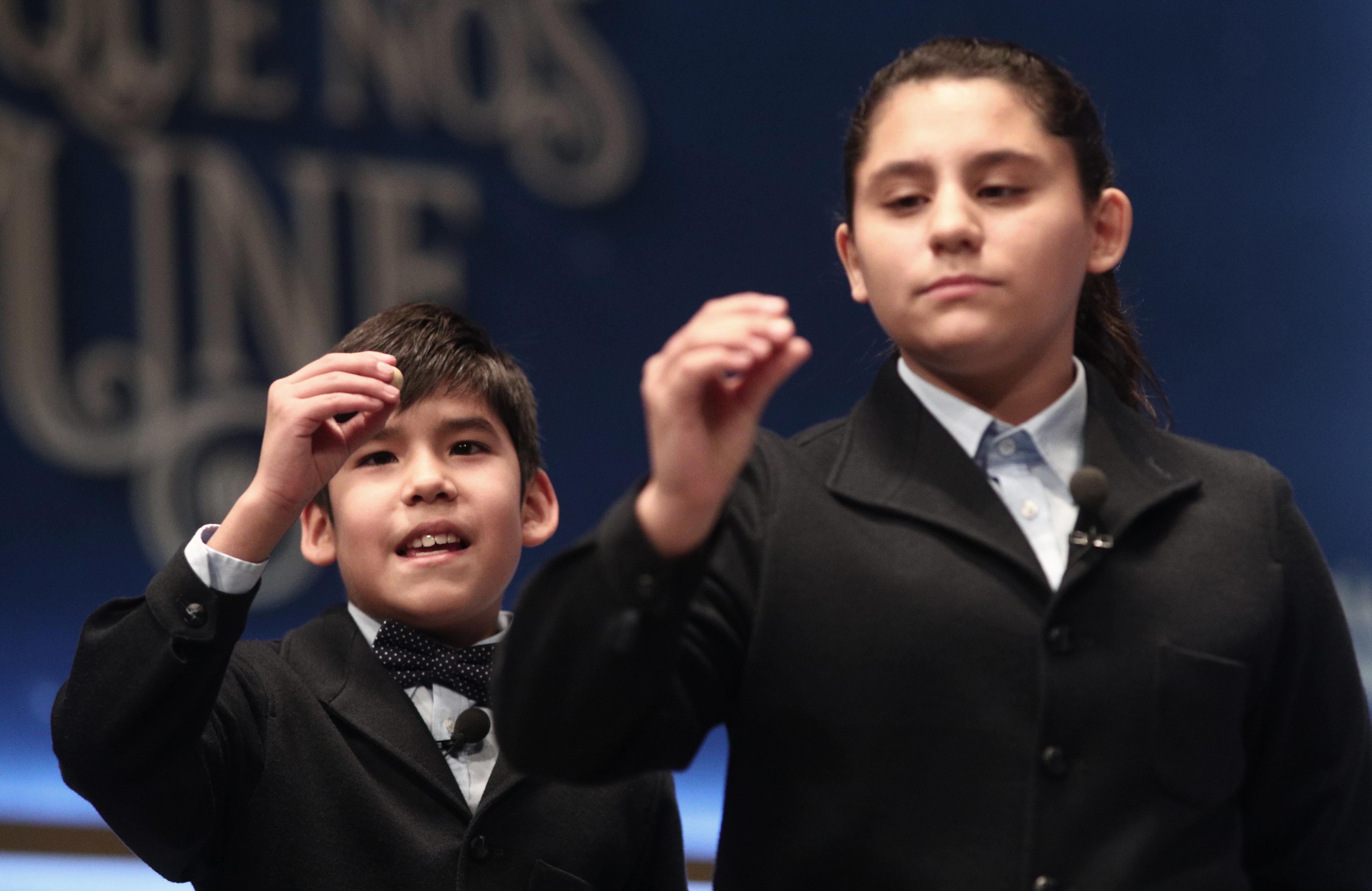 Dos de los niños de la residencia de San Ildefonso, cantan uno de los quintos premios de la Lotería de Navidad, durante la celebración del Sorteo Extraordinario de la Lotería de Navidad 2019.