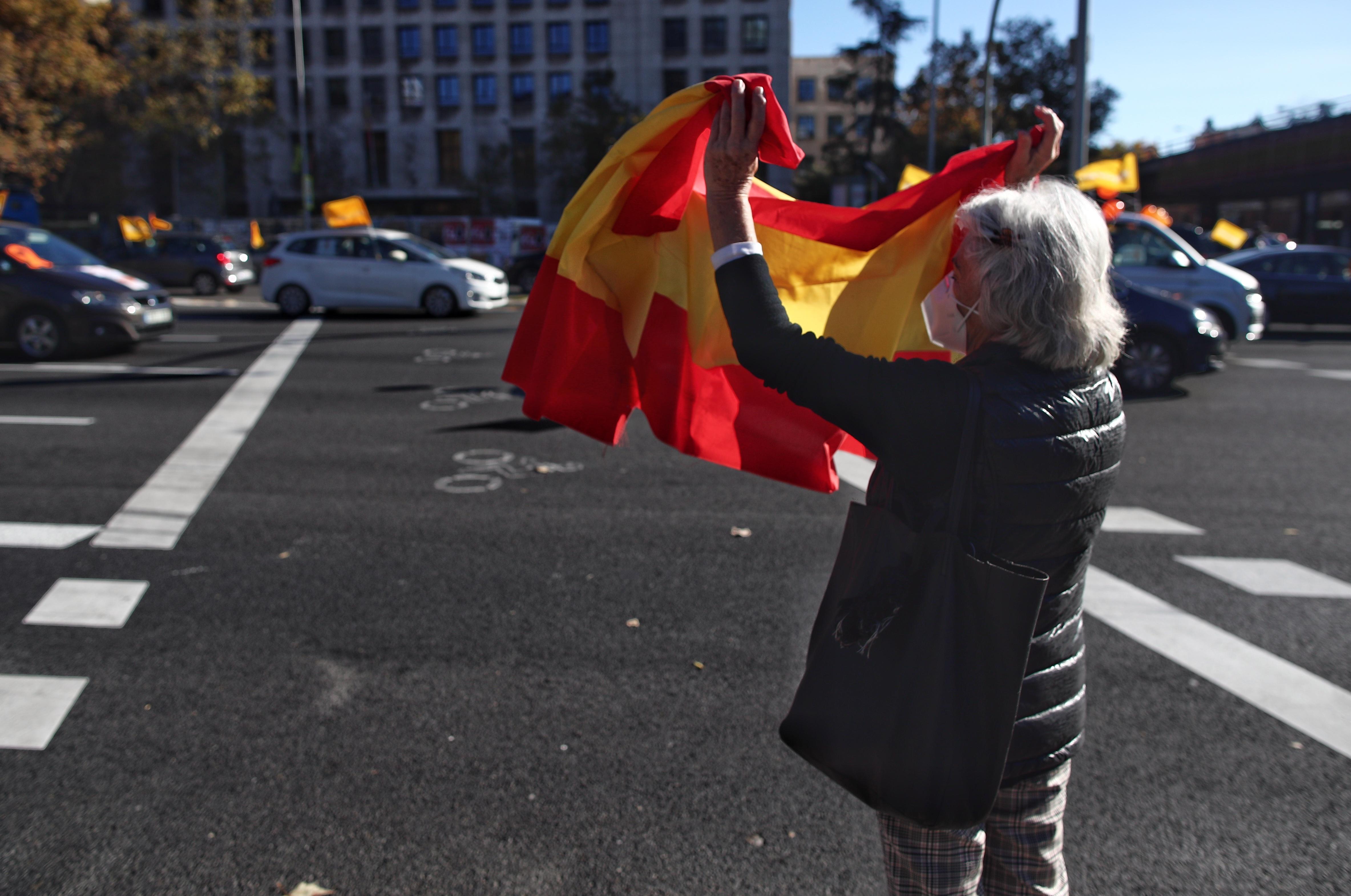 Una mujer agita una bandera de España durante una manifestación con vehículos / EP
