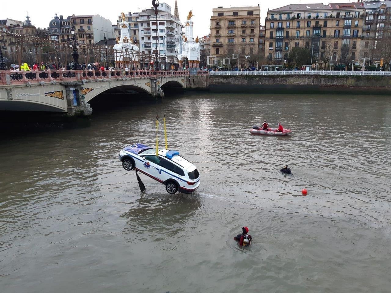 Momento en el que el vehículo policial es rescatado del río Urumea, en San Sebastián.EP