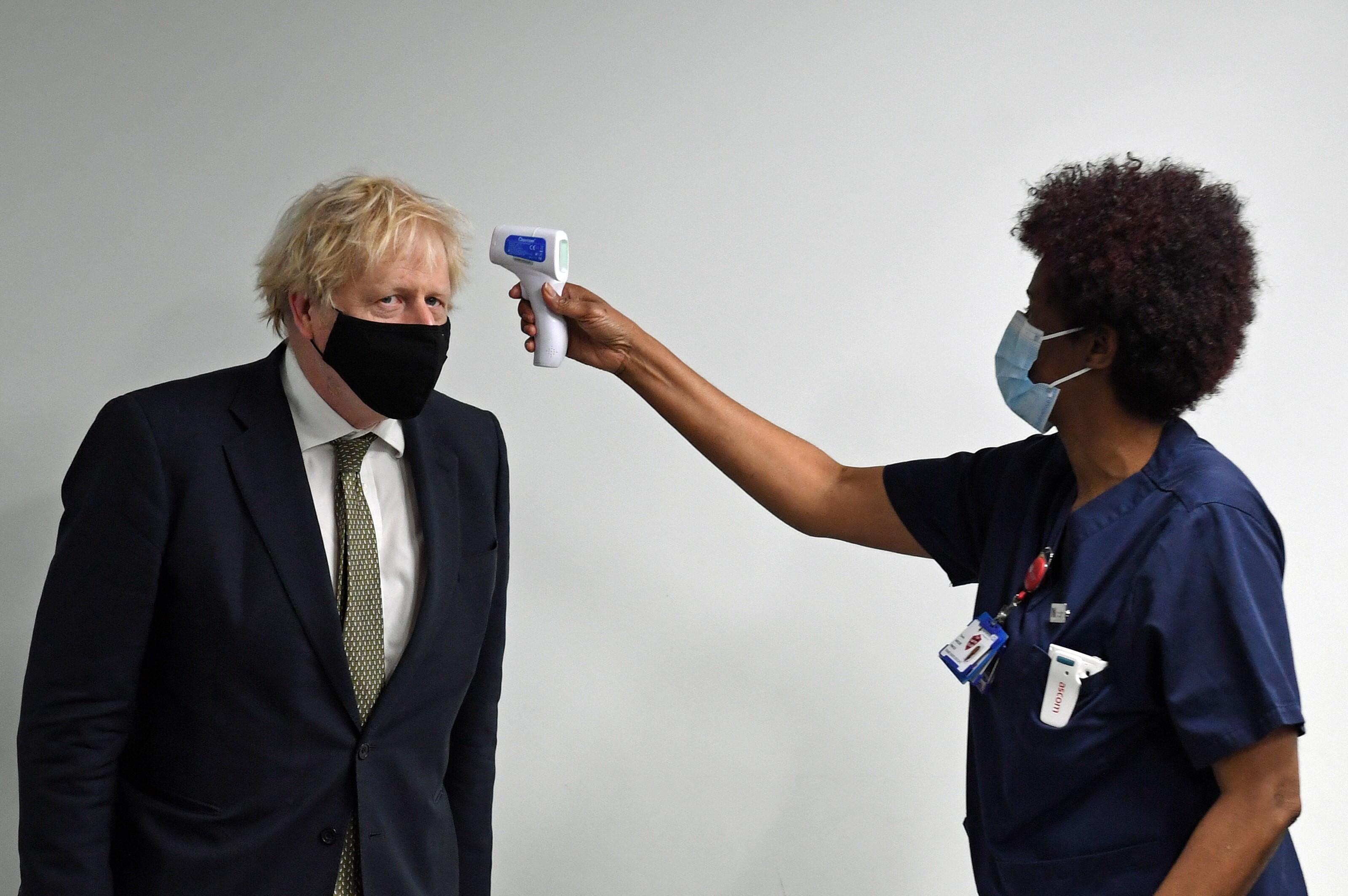 Una enfermera mide la temperatura a Boris Johnson.