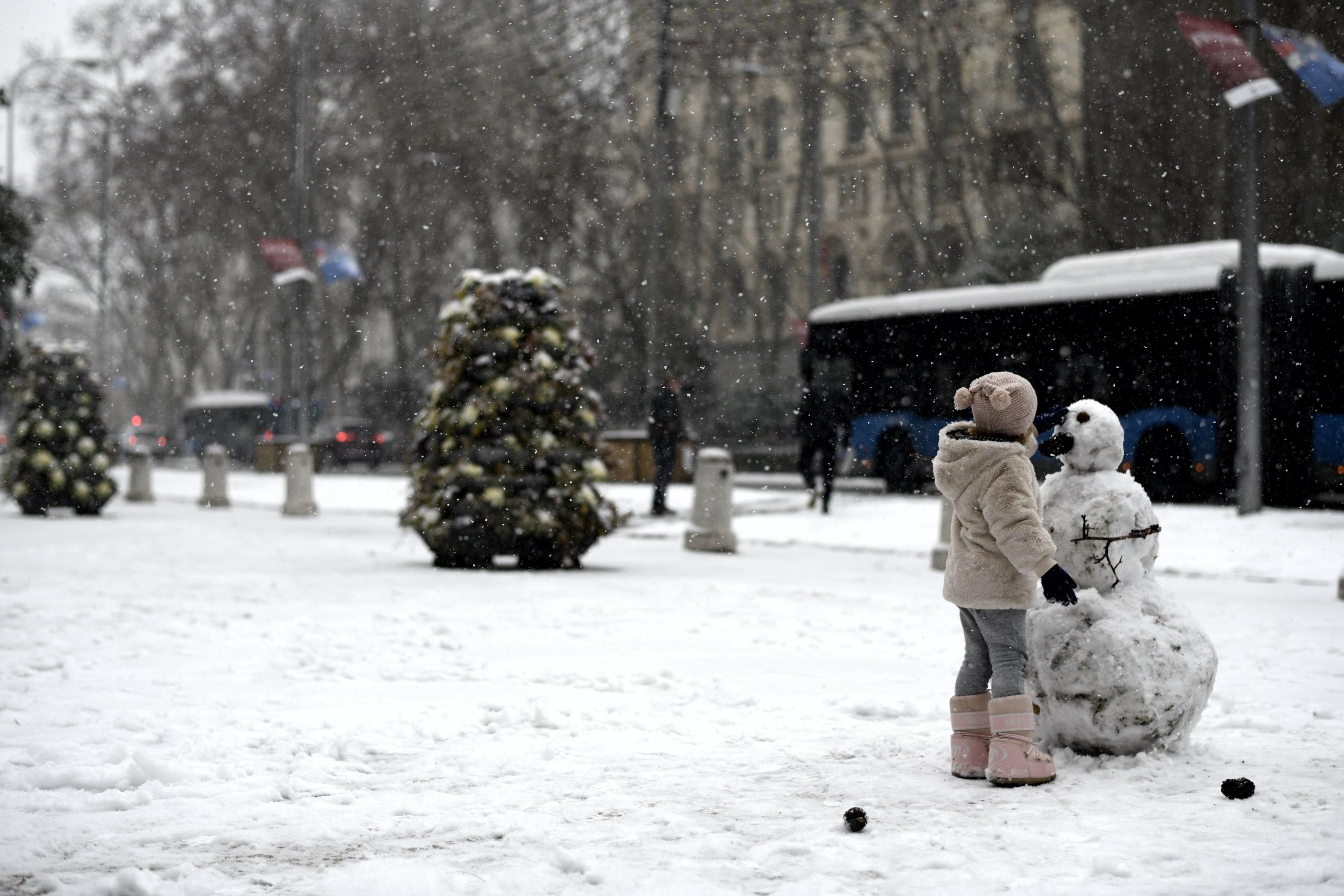 Imagen de archivo de una niña jugando con la nieve