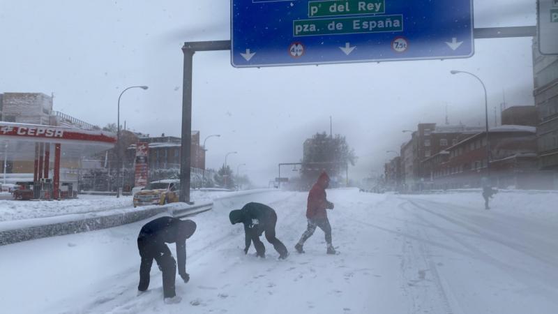 Tres personas juegan con la nieve en el acceso a la M 30