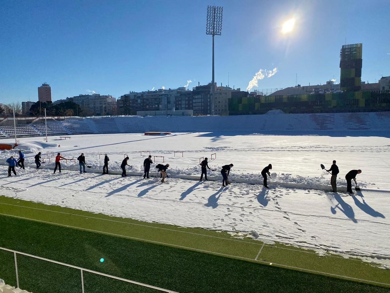 Vocales vecinos de Chamberí y personal del área de Deportes ayudan a retirar la nieve del estadio Vallehermoso.