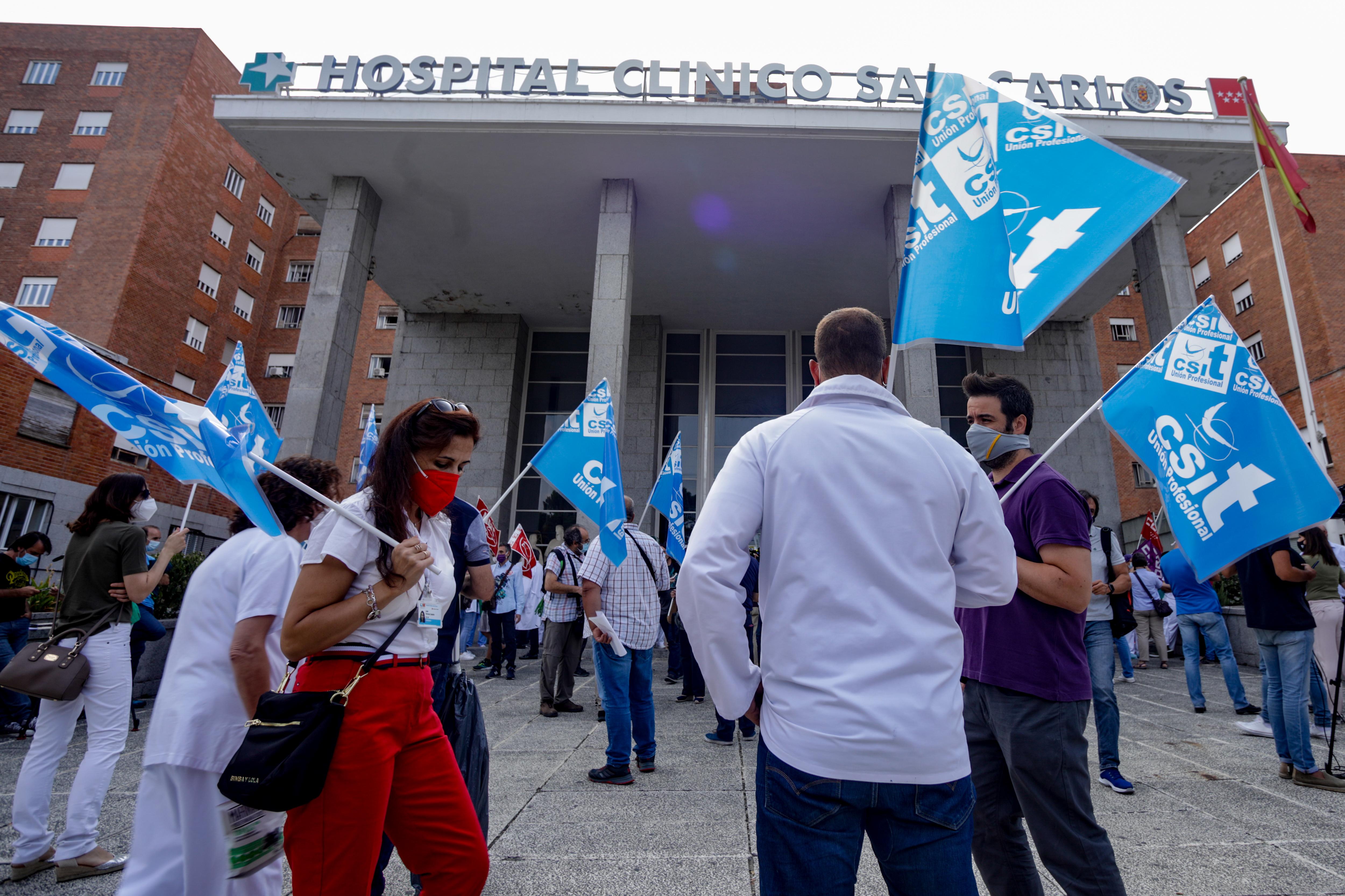 Varios sanitarios se concentran con pancartas como signo de protesta frente al Hospital Clínico San Carlos, en Madrid