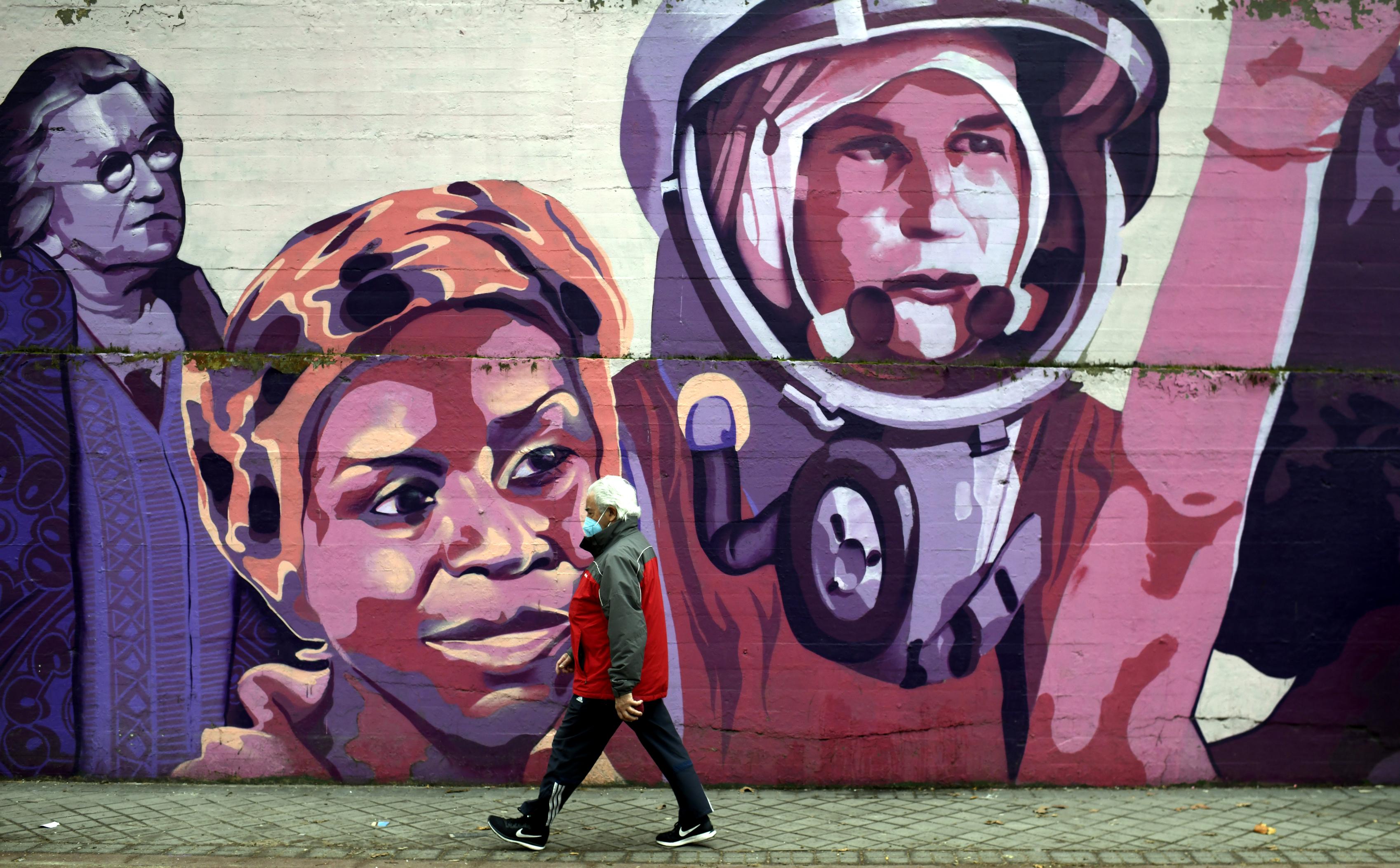 Un hombre pasa por el mural feminista en el polideportivo municipal de la Concepción en el distrito de Ciudad Lineal. Fuente: Europa Press.