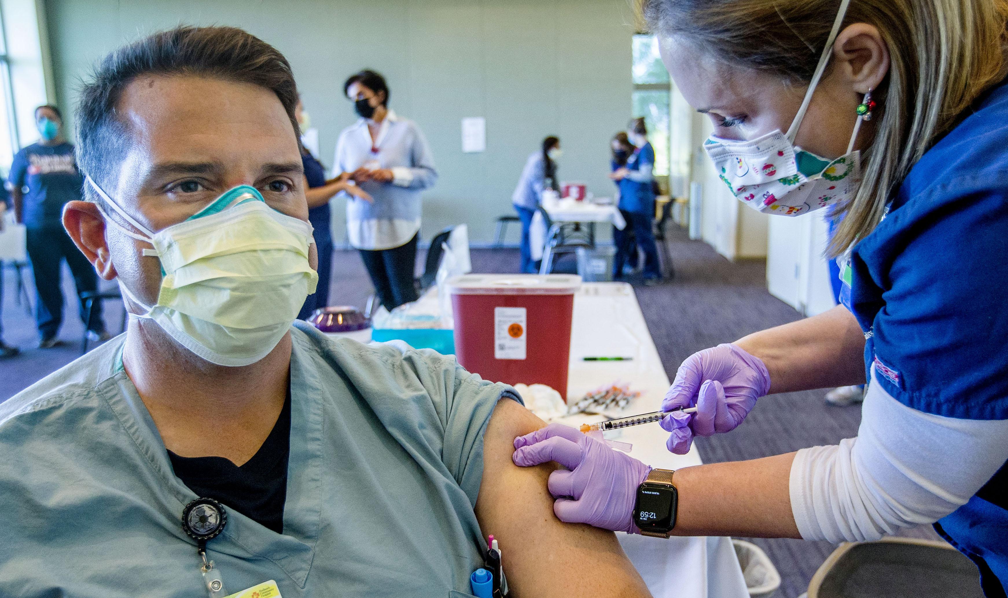 Un sanitario en primera línea de la lucha contra el coronavirus recibe la vacuna de Pfizer BioNTech en California. Fuente: EP.