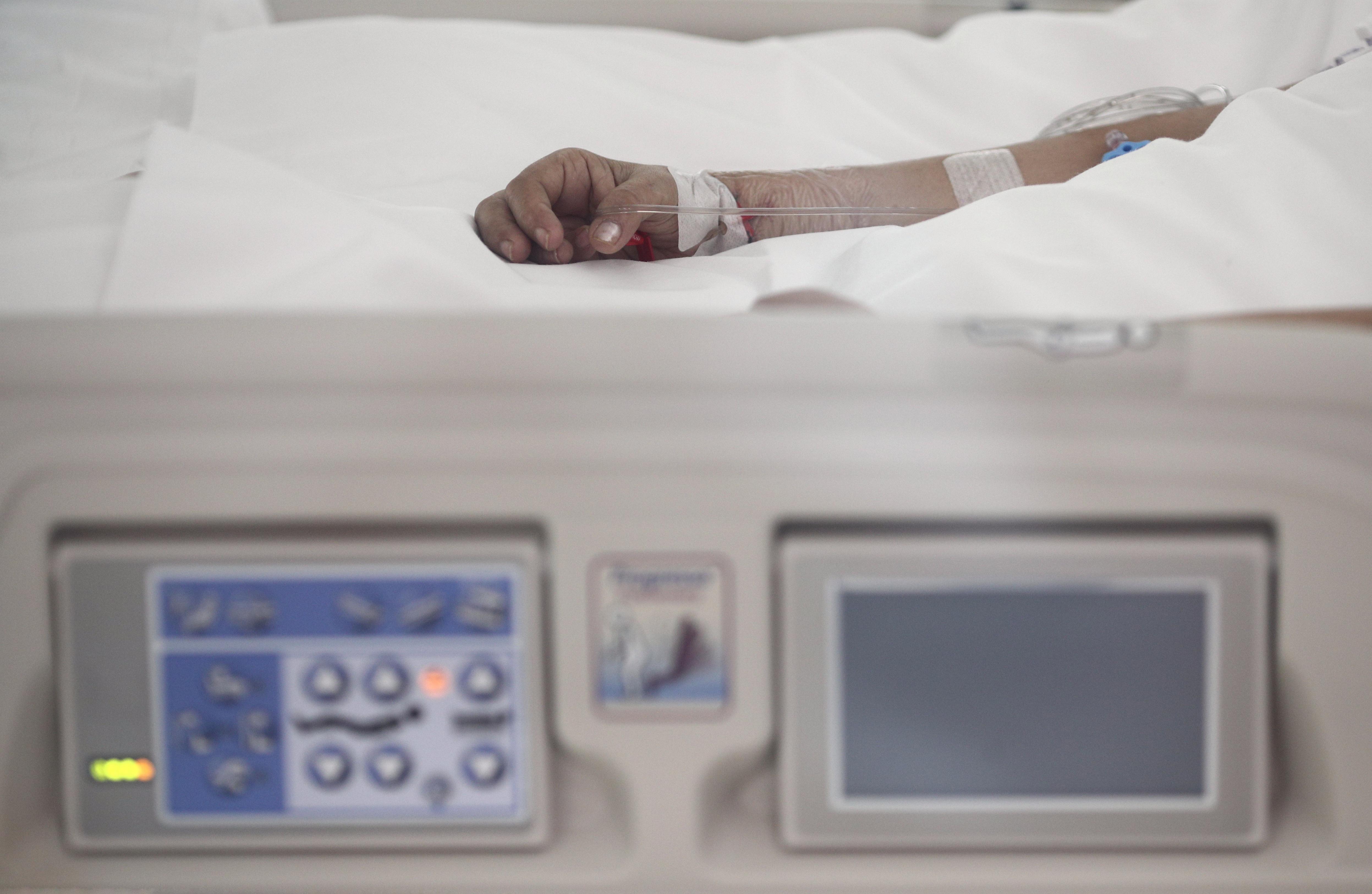 Mano de un enfermo con vía subcutánea en una cama de la UCI del Hospital de Emergencias Isabel Zendal. EP