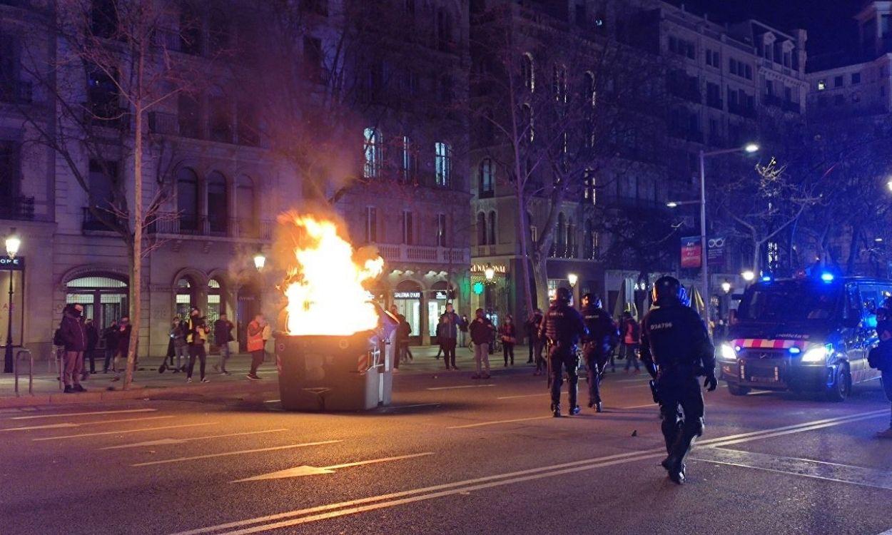 Queman un contenedor en el paseo de Gràcia de Barcelona durante la manifestación en apoyo a Pablo Hasel