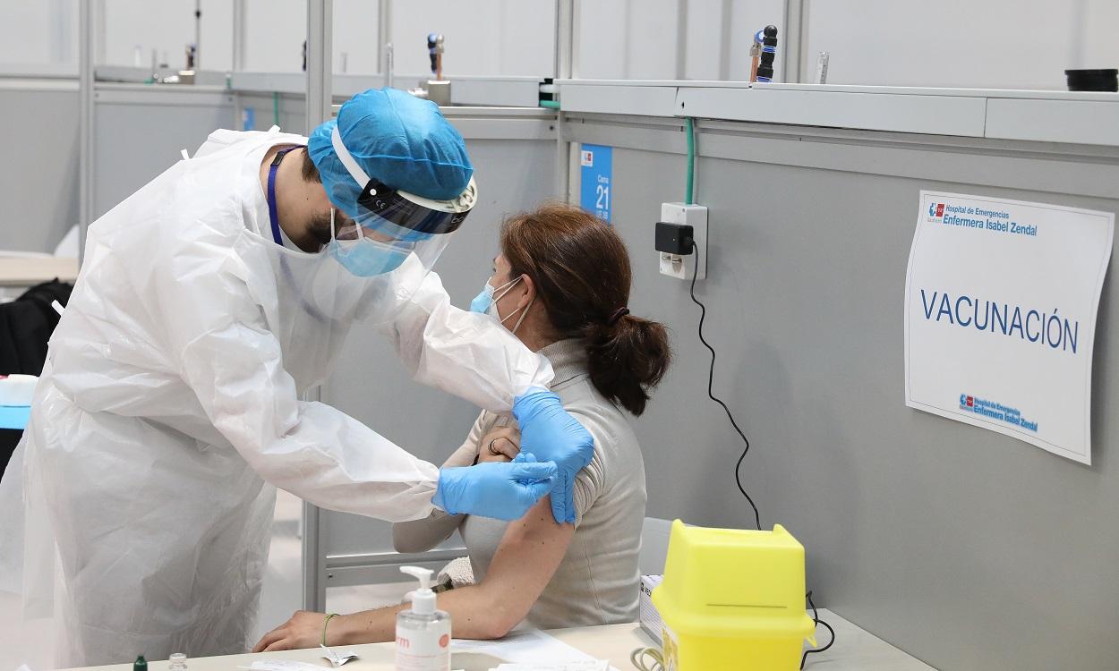 Un sanitario vacuna a una mujer en el Hospital Isabel Zendal de Madrid. EP