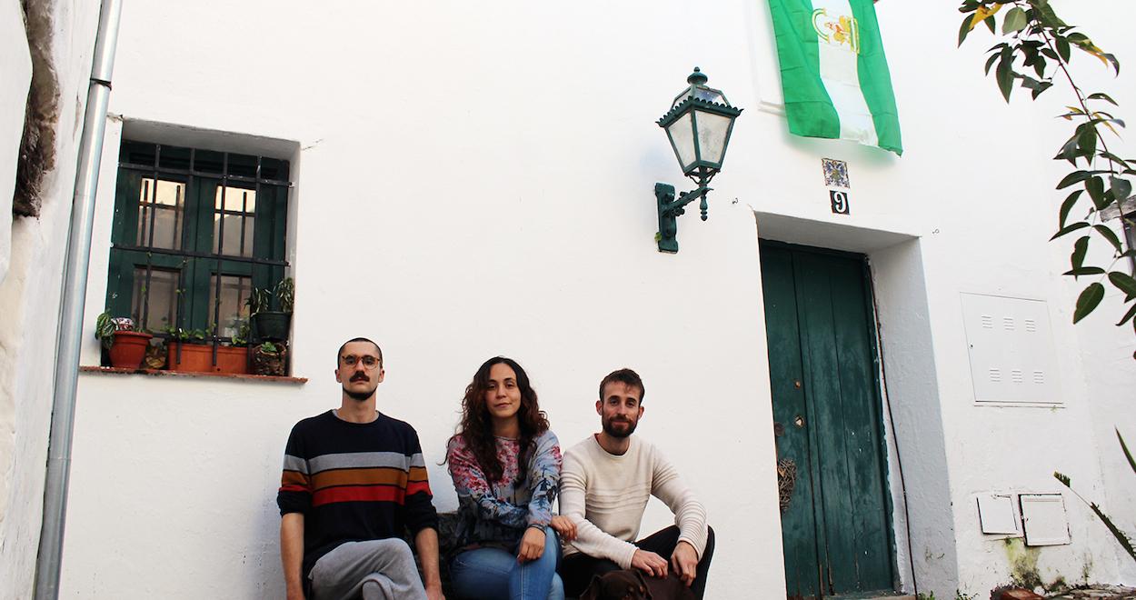 Miguel León, su prima Paloma León y la pareja de esta, Moisés Díaz, posan a la puerta de la casa familiar recuperada.