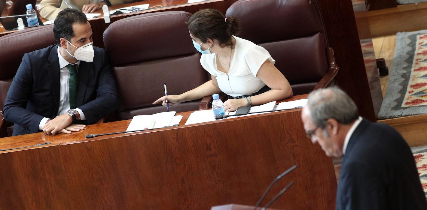 El vicepresidente y la presidenta de la Comunidad de Madrid, Ignacio Aguado e Isabel Díaz Ayuso, charlan durante la intervención del portavoz del PSOE en la Asamblea de Madrid, Ángel Gabilondo. EP