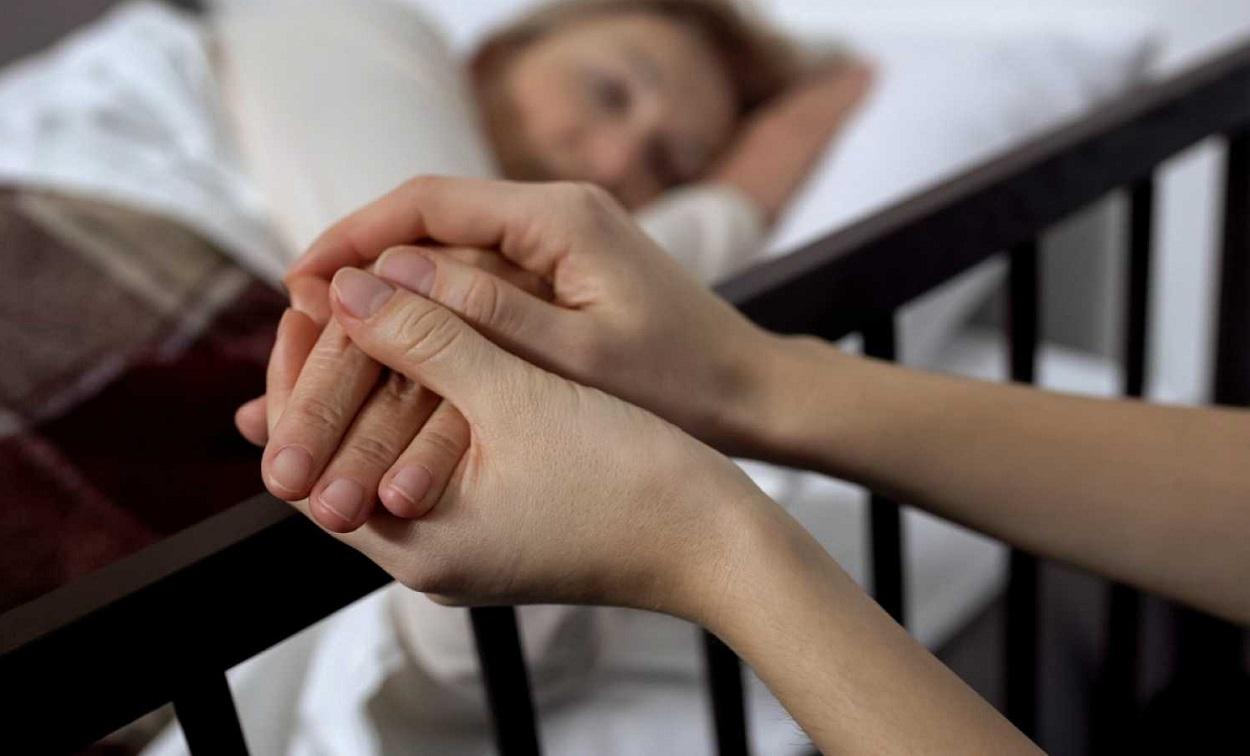 Una mujer sostiene la mano de una paciente. Fuente RTVE