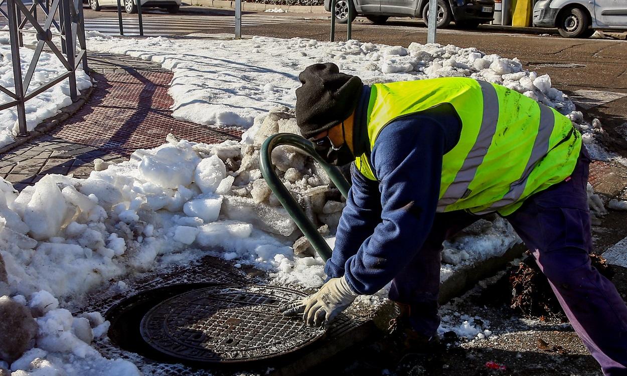 Un operario limpia nieve del alcantarillado de Madrid. EP