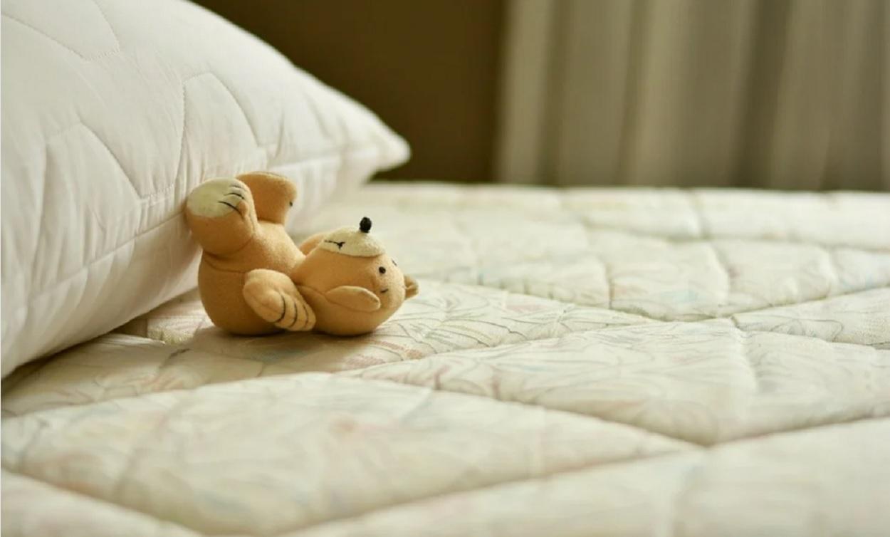 Un peluche sobre una cama. Fuente Pixabay