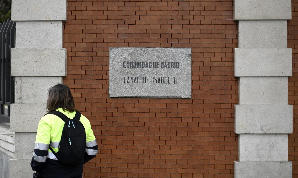 Una persona pasa por una señal del Canal de Isabel II, en Madrid. EP