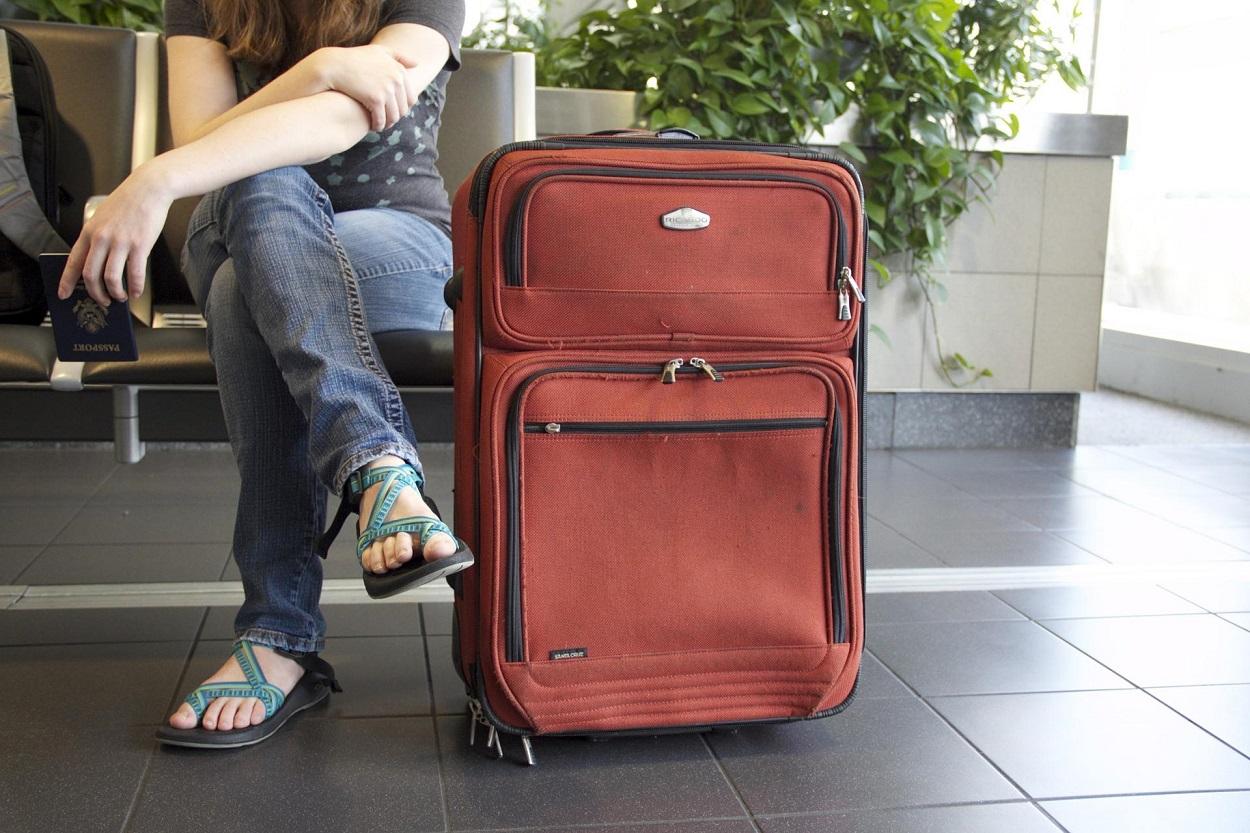 Una persona con su maleta esperando a viajar. Pixabay