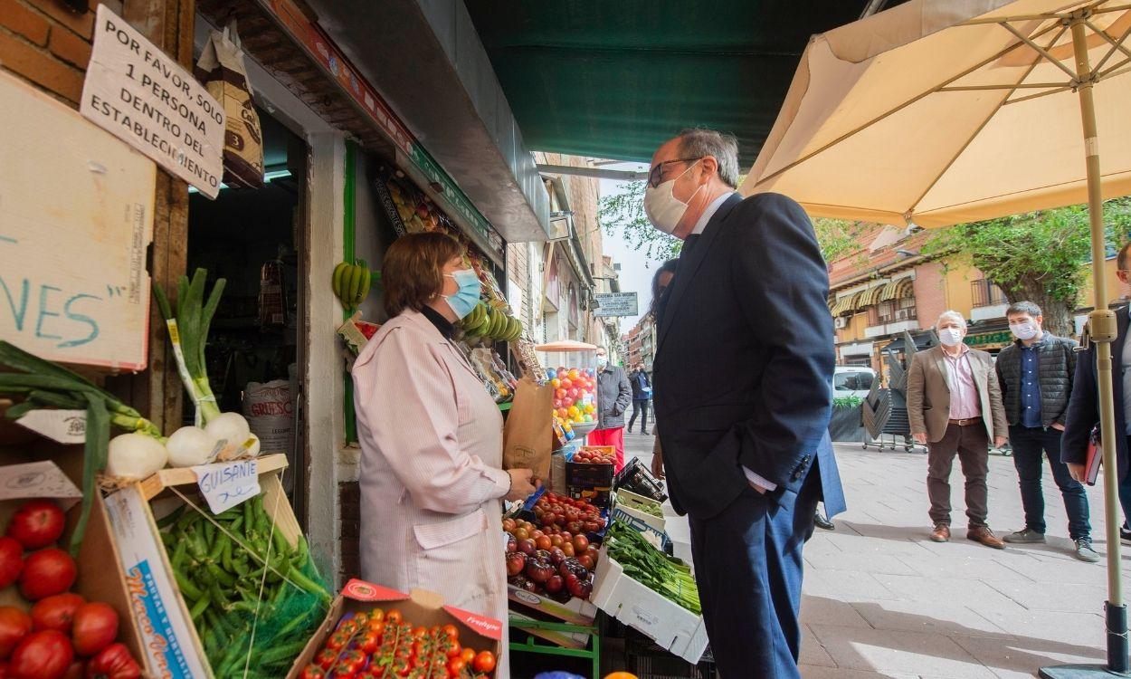 El candidato del PSOE a la Presidencia de la Comunidad de Madrid, Ángel Gabilondo, conversa con la trabajadora de un comercio durante una visita a Getafe