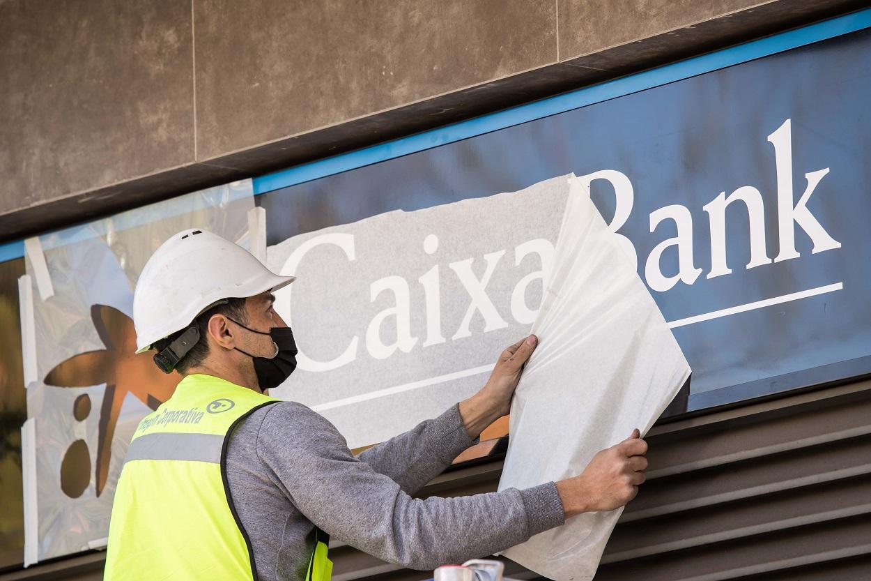 Un trabajador de CaixaBank cambia la rotulación