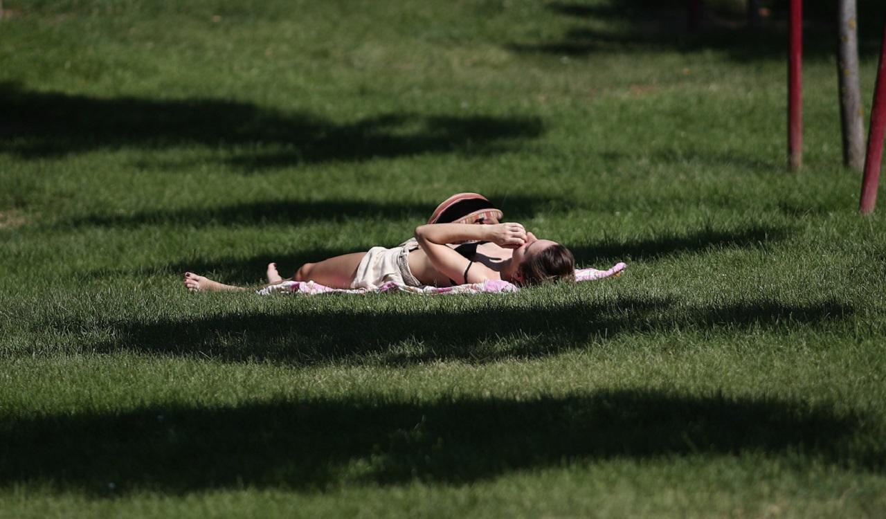 Una joven toma el sol en un parque de Madrid. EP archivo