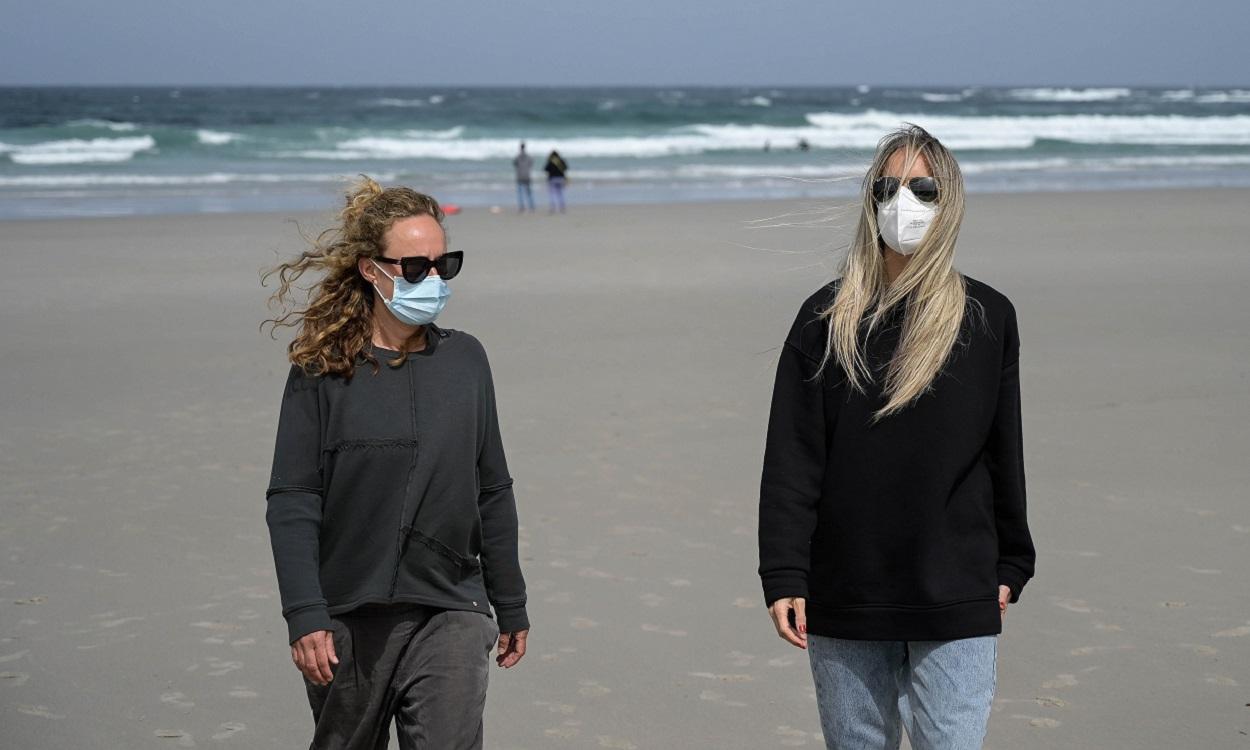 Dos mujeres llevan mascarilla en la Playa das Salseiras, A Coruña. EP