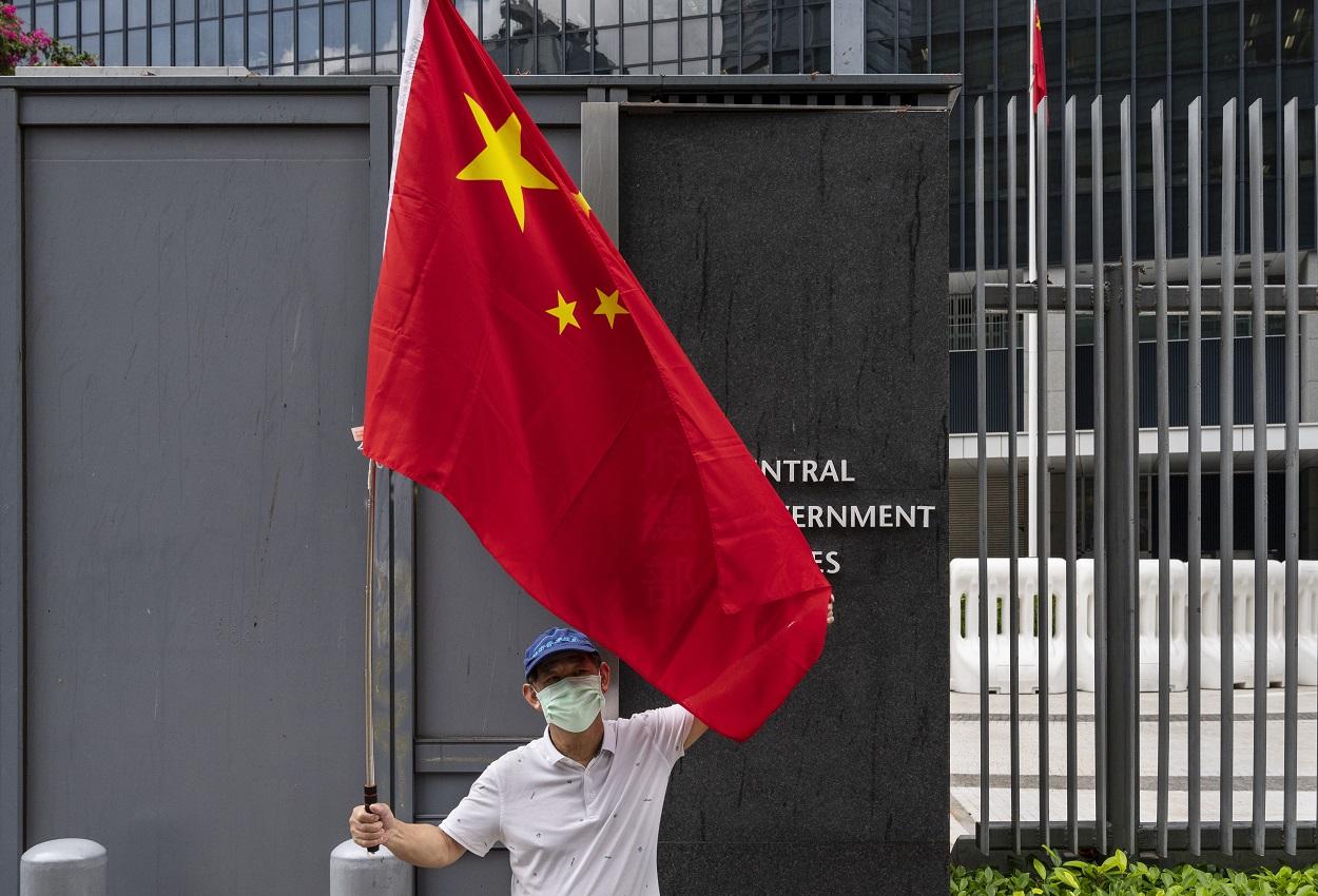 Un ciudadano sostiene la bandera china. Europa Press