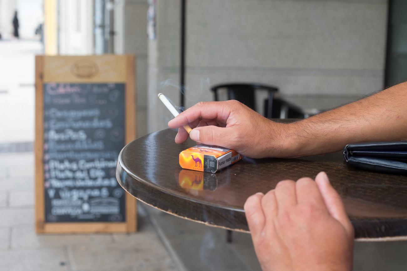 Imagen de una persona fumando en una terraza en Galicia elprimer día en que se prohibió fumar en la vía pública, el pasado 13 de agosto de 2020 (Foto: Europa Press).