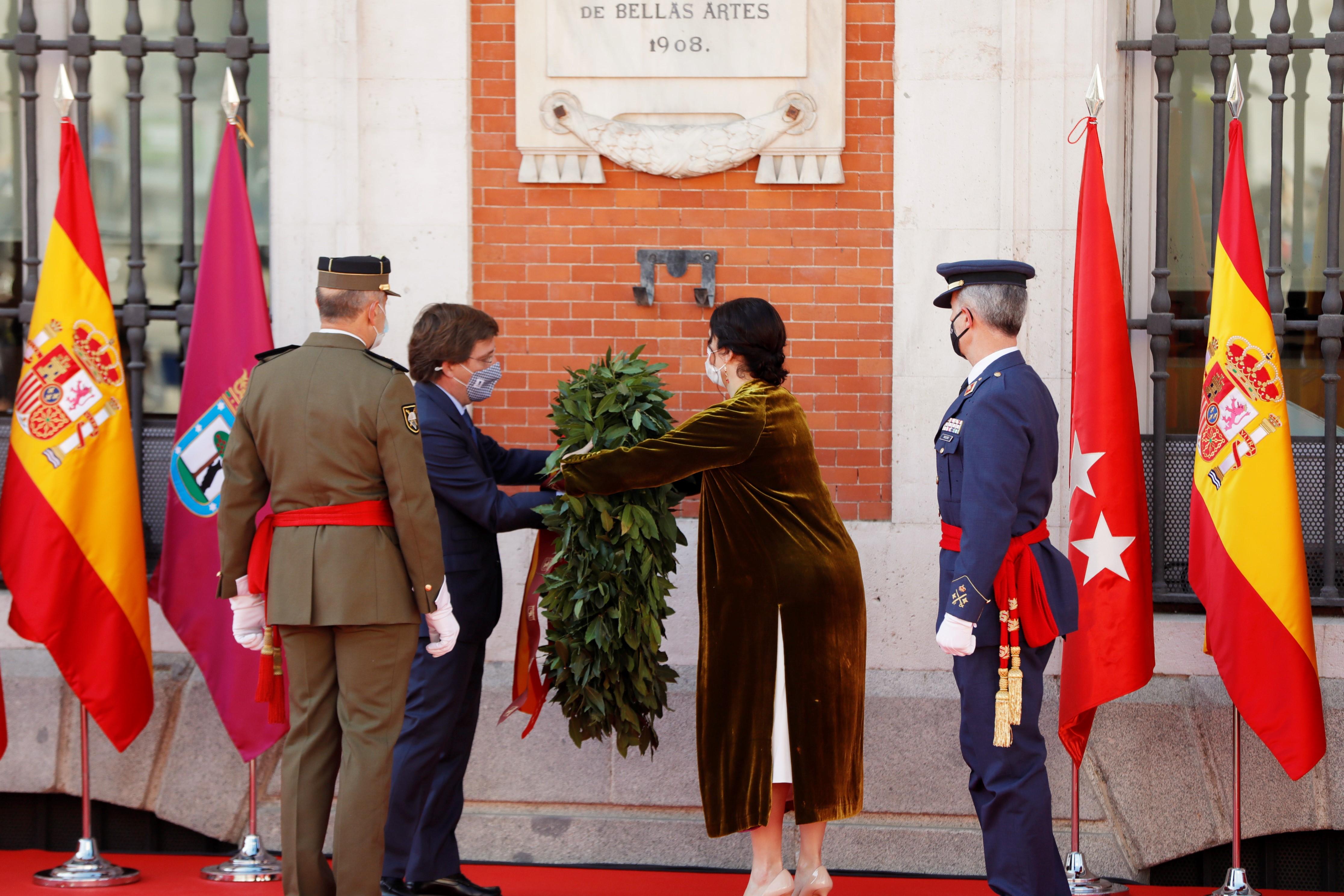 La presidenta de la Comunidad de Madrid, Isabel Díaz Ayuso (i), y el alcalde de Madrid, José Luis Martínez-Almeida (d), durante el acto cívico militar en la Puerta del Sol con motivo del Día de la Comunidad de Madrid, a 2 de mayo de 2021.