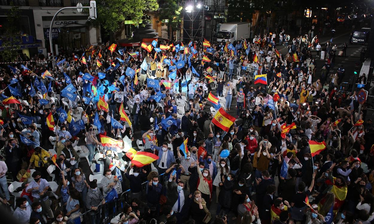 Seguidores del Partido Popular celebran con banderas de España frente a la facha de Génova 13. EP