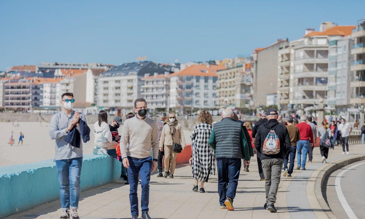 Varias personas pasean por el paseo marítimo de Sanxenxo, Pontevedra, Galicia. EP