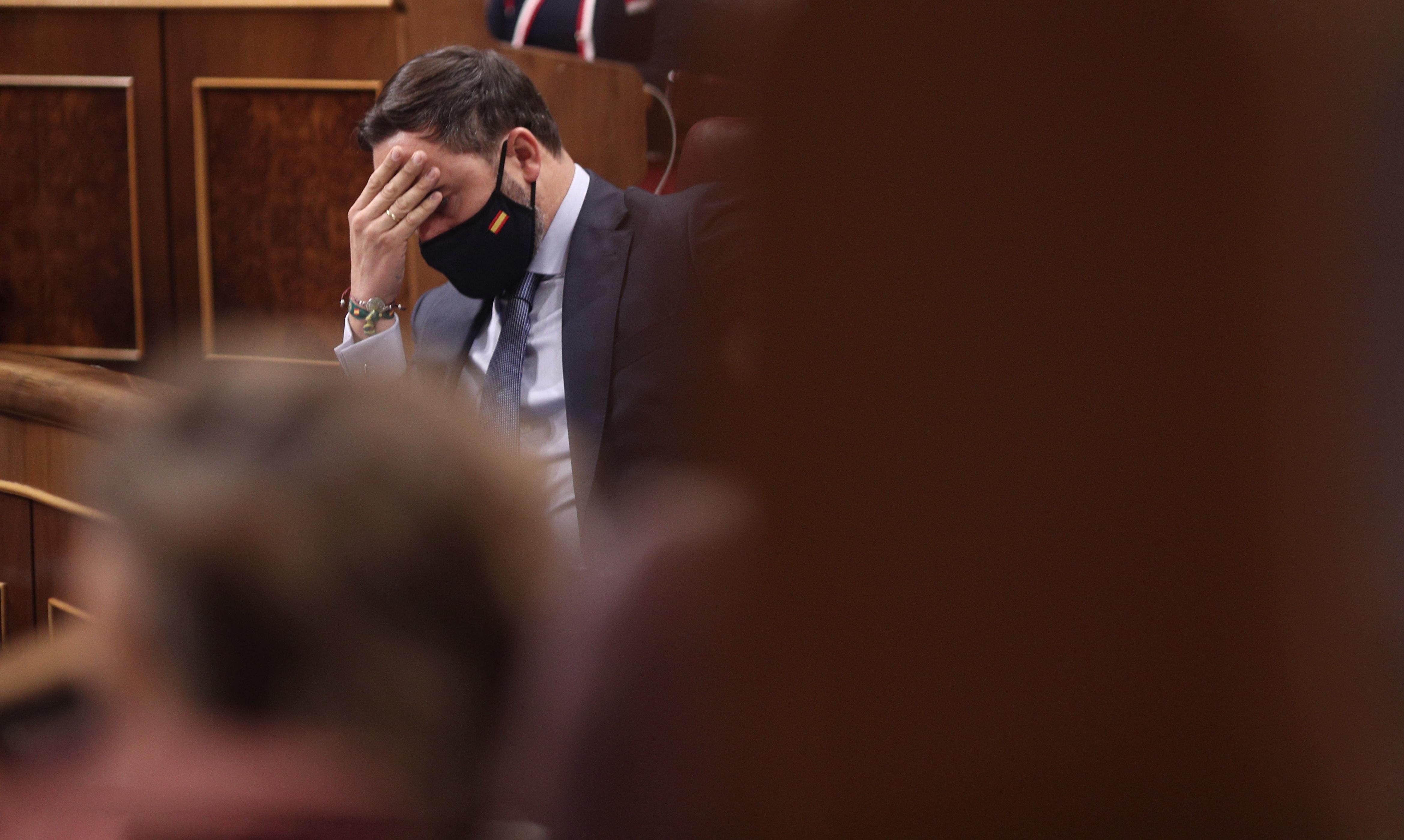El presidente de Vox, Santiago Abascal, mira hacia abajo durante la segunda sesión del pleno en el que se debate la moción de censura planteada por Vox