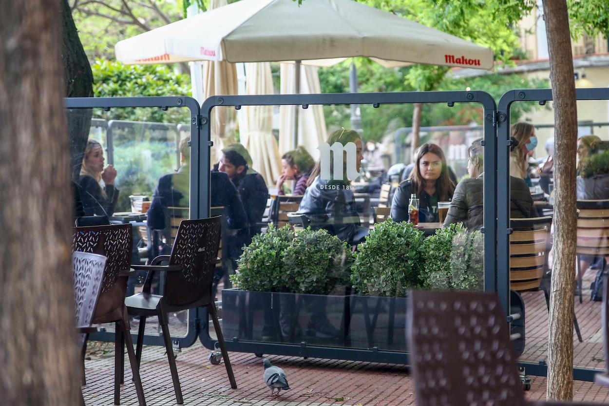 Varias personas en la terraza de una cafetería en la plaza de Olavide en el barrio de Chamberí durante el primer día laboral tras el estado de alarma