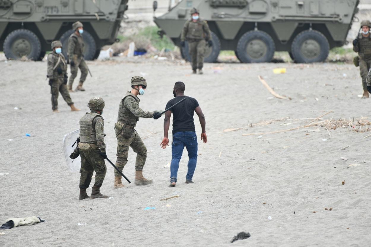 Militares del ejército español efectúan una devolución en caliente a uno de los migrantes que han entrado en Ceuta procedente de Marruecos. Fuente: Europa Press.