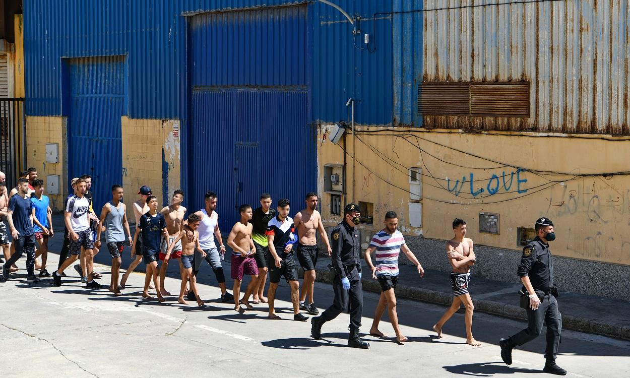 Un grupo de jóvenes migrantes marroquíes en fila en las inmediaciones de una nave. EP