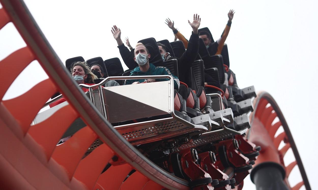 Varias personas con mascarilla subidas en la atracción 'El abismo' del Parque de Atracciones. EP