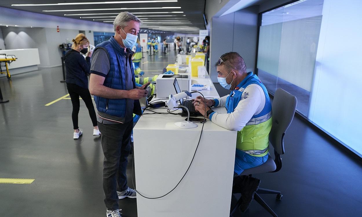 Un hombre espera para ser registrado, después de recibir la dosis con la vacuna de Pfizer en el Wanda Metropolitano. EP