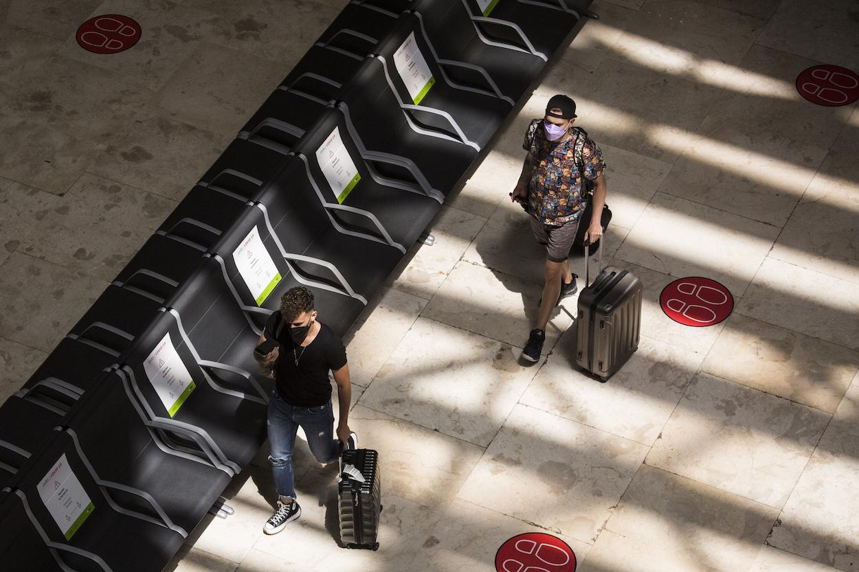 Dos personas con maletas en la terminal T4 del Aeropuerto Adolfo Suárez Madrid Barajas