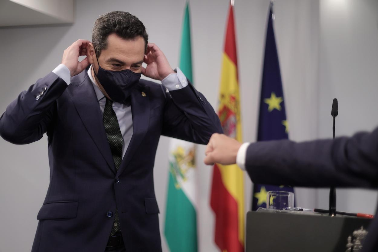 El presidente Juan Manuel Moreno Bonilla se pone la mascarilla tras su rueda de prensa posterior a la reunión con Pedro Sánchez. EDUARDO PARRA/EP